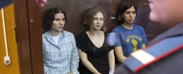 Feminist punk group Pussy Riot members sit in a glass cage at a court room in Moscow Friday. (AP Photo/Misha Japaridze)