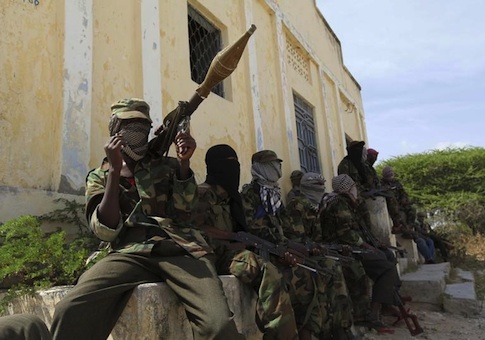 Al Shabaab soldiers sit outside a building during patrol