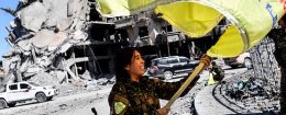 Rojda Felat, a Syrian Democratic Forces (SDF) commander, waves her group's flag at the iconic Al-Naim square in Raqa on October 17, 2017. US-backed forces said they had taken full control of Raqa from the Islamic State group, defeating the last jihadist holdouts in the de facto Syrian capital of their now-shattered "caliphate". / Getty Images
