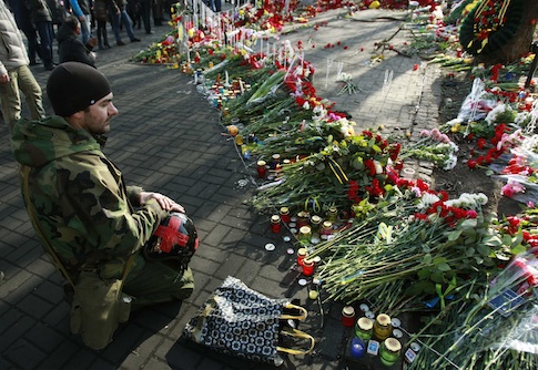 A man mourns at the site where anti-Yanukovich protesters have been killed in recent clashes in Kiev