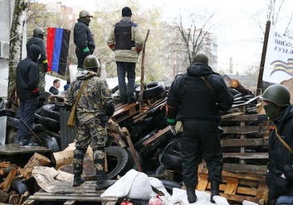 Pro-Russian men stand guard at a barricade near the police headquarters in Slaviansk