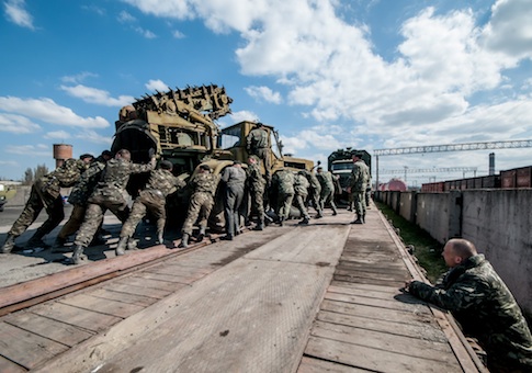 Russian soldiers load Ukrainian military equipment to be shipped to Ukraine
