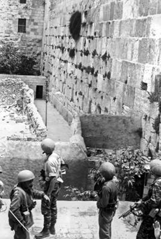 The first paratroopers reach the Western Wall. Left to right, Moshe Stempel, Yoram Zamosh, Yair Levanon, Aryeh Ben Yaakov.   Credit: Courtesy of IDF & Defense Establishment Archives, photo by Amos Zuker.