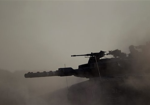 An Israeli tank takes a position along the Israel-Gaza Border