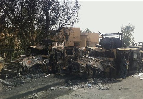 Iraqi army armored vehicles are seen burned on a street of the northern city of Mosul