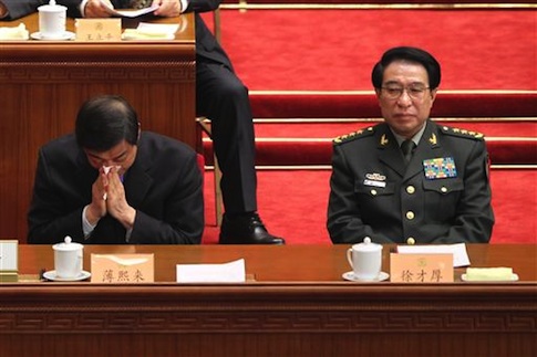 Bo Xilai, left, then Secretary of the Chongqing Municipal Committee of the Communist Party of China (CPC) and son of former Chinese Vice Premier Bo Yibo, blows his nose next to general Xu Caihou, then Vice Chairman of the Central Military Commission of China