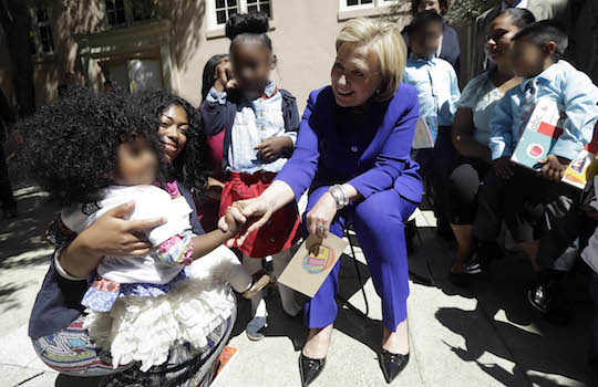 Hillary Clinton (seated, obviously) attempts to play with a frightened child. (AP)