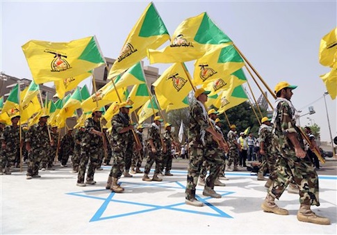 Supporters of Iraqi Hezbollah brigades marching in military uniforms step on a representation of an Israeli flag in Baghdad