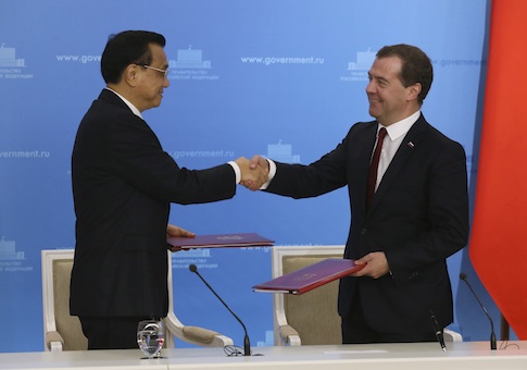 Russia's Prime Minister Dmitry Medvedev (R) shakes hands with China's Premier Li Keqiang during a signing ceremony in Moscow
