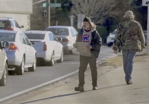 Homeless veteran Michael Wilson holds a sign up in front of traffic on Tuesday, Jan. 21,2014, in Fort Walton Beach, Fla.