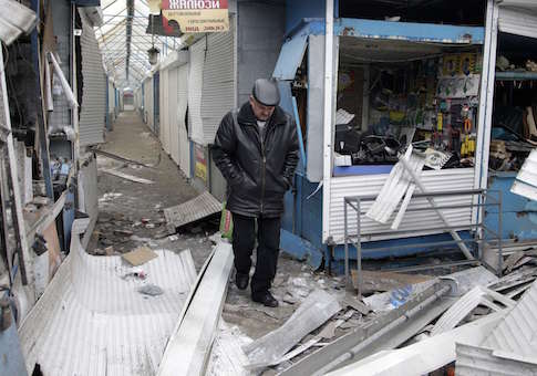 A man walks past a shop which was recently damaged by shelling, at a local market in Donetsk, eastern Ukraine, January 29, 2015