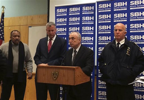 New York City Mayor Bill de Blasio, second left, stands by as New York Police Department Commissioner William Bratton, second right,†speaks at a news conference at St. Barnabas Hospital in the Bronx section of New York, early Tuesday, Jan. 6, 2015