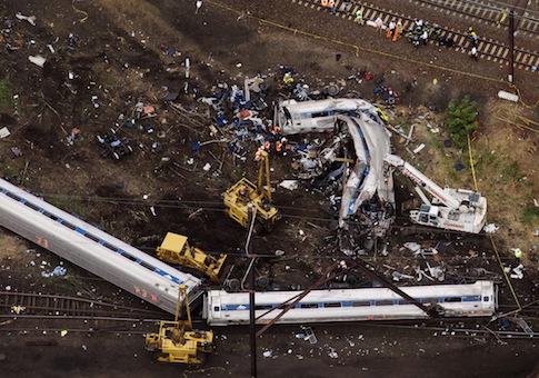 Emergency workers look through the remains of a derailed Amtrak train in Philadelphia, Pennsylvania