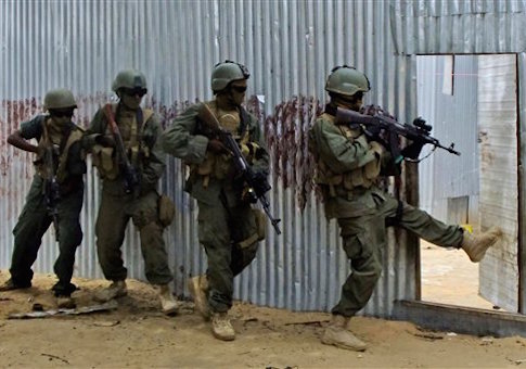 Masked Somali national army (SNA) soldiers search through homes for al-Shabaab fighters, during an operation in Ealsha Biyaha, Somalia, Saturday, June, 2, 2012