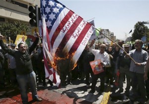 Iranian demonstrators burn a representation of the U.S. flag reading "down with America," in Arabic and Persian
