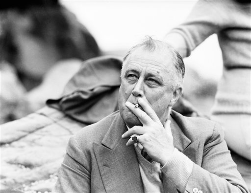 U.S. President Franklin D. Roosevelt smokes a cigarette as he sits on the rocks at Herring Cove on Campobello Island, New Brunswick, Canada on July 30, 1936. President Roosevelt and family have a summer home on the Island, located off the east coast of Canada. (AP Photo/George R. Skadding)