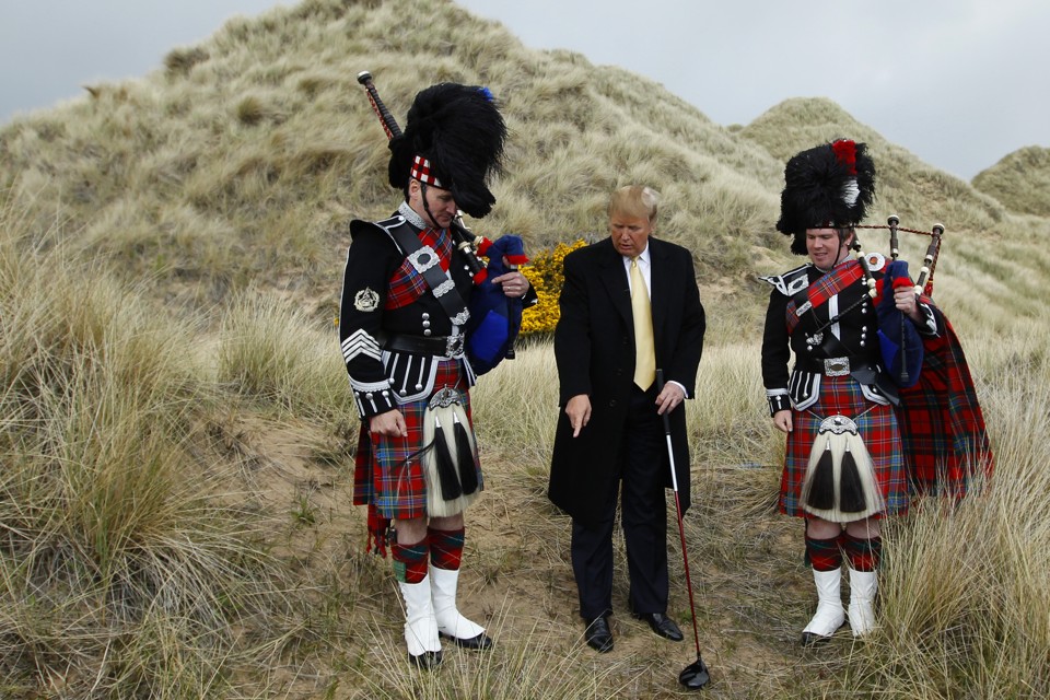 U.S. property mogul Donald Trump (C) poses next to bagpipers during a media event on the sand dunes of the Menie estate, the site for Trump's proposed golf resort, near Aberdeen, north east Scotland May 27, 2010.  REUTERS/David Moir (BRITAIN POLITICS - Tags: SPORT GOLF BUSINESS) - RTR2EF9L