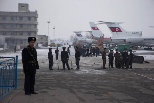 North Korean workers labor next to Air Koryo jets lined up on the tarmac of the airport near Pyongyang, North Korea / AP