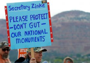 A protester calls on Secretary Zinke not to privatize monuments / Getty