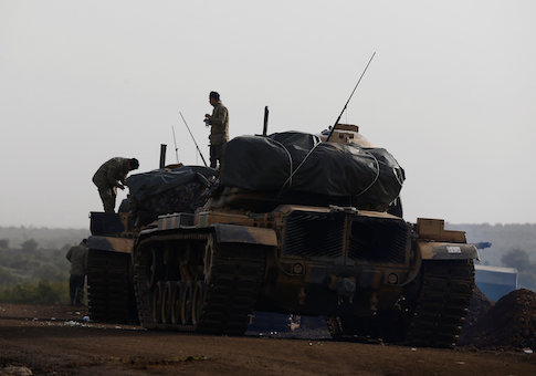 Turkish soldiers stand on tanks in a village on the Turkish-Syrian border in Gaziantep province, Turkey
