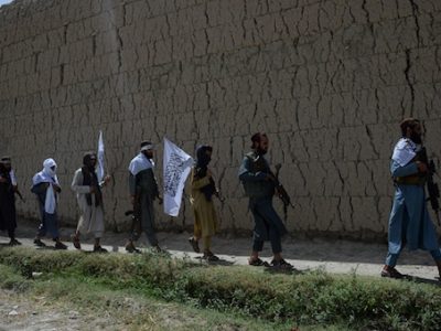 Afghan Taliban militants walk as they took to the street to celebrate ceasefire