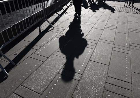 Shadow of a NYPD officer during a press conference on new barriers to prevent terror attacks