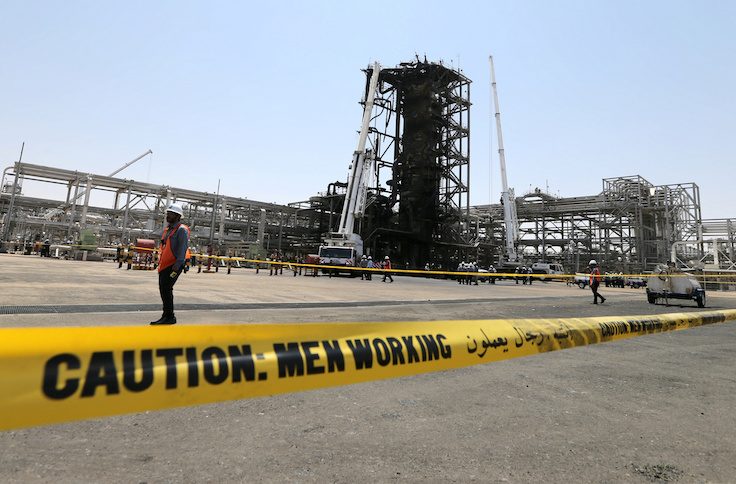 Workers are seen at the damaged site of Saudi Aramco oil facility in Khurais, Saudi Arabia