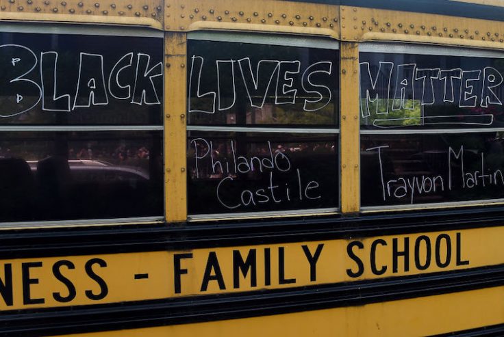 A school bus drives past demonstrators protesting the death of George Floyd / Getty Images