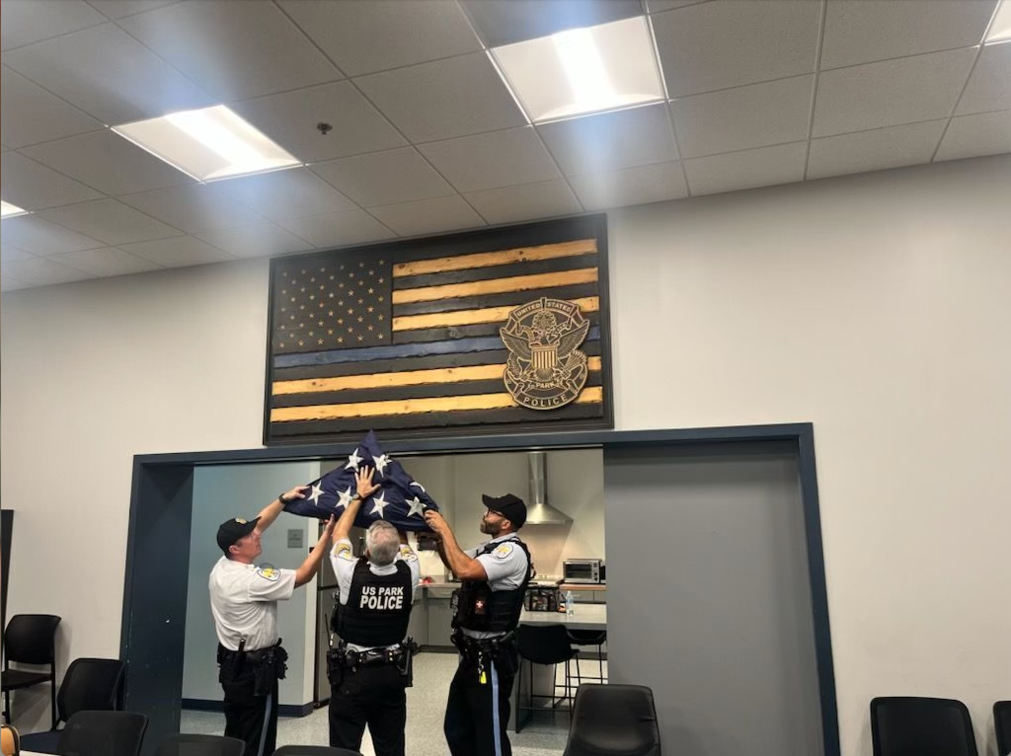 U.S. Park Police officers raise an American flag they salvaged during the protest Wednesday. (Photo Credit: Office of Congressman Bruce Westerman)